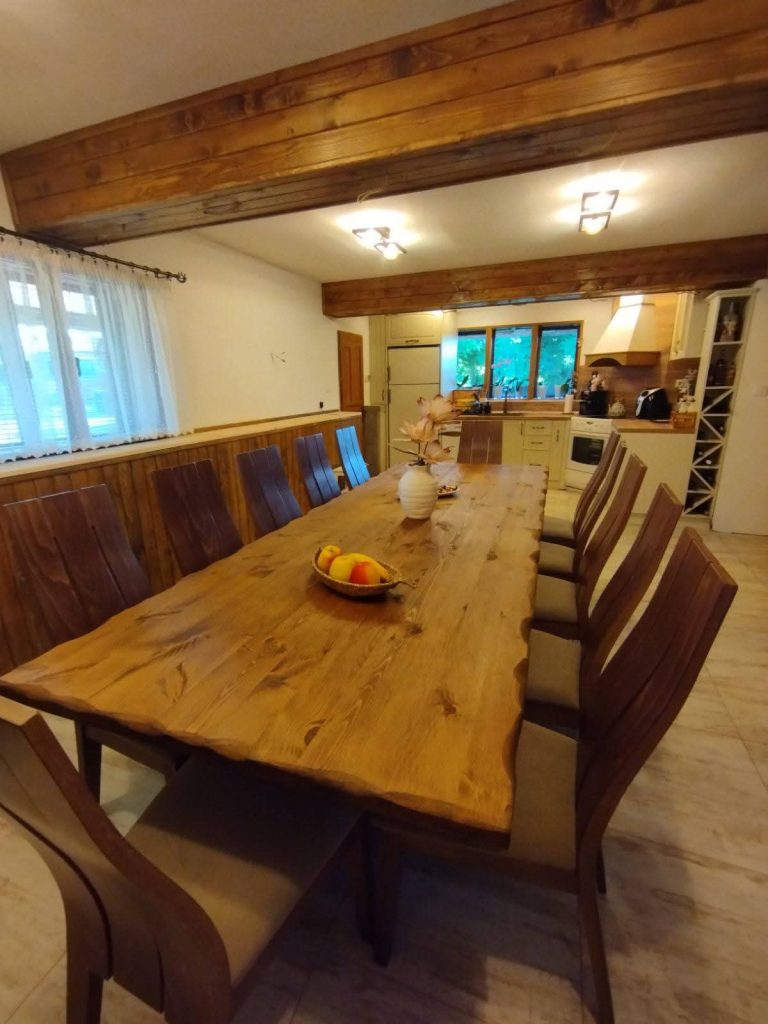 Live Edge Black Pine Table Top Slab For Luxurious Handcrafted Dining Table In Rustic Natural Home Interior. Black pine tree with dark green, dense needles and pine cones